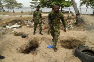 The ground is pockmarked with holes where residents have dug down to pipelines, some filled with shiny oil and water.  By PIUS UTOMI EKPEI (AFP)