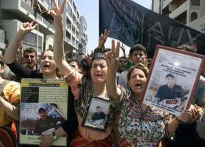 The mother (R) and sister (2nd R) of Massinissa Guermah hold pictures of him during a demonstration in April 2002, a year after he was killed by police.  By HOCINE ZAOURAR (AFP/File)