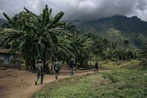 Troops patrol the village of Mwenda, which recently came under attack by the ADF.  By ALEXIS HUGUET (AFP)