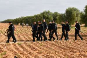Tunisian police pictured during the operation to clear the migrants camp.  By FETHI BELAID (AFP)