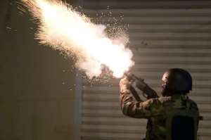 Tunisian security forces fire tear gas as protesters block a street on Tuesday night.  By FETHI BELAID (AFP)