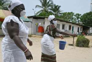 Two female healers sprinkled the royal courtyard with a special liquid to purify it.  By ISSOUF SANOGO (AFP/File)