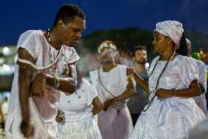 Umbanda faithfuls pray and dance to Iemanja, the goddess of the sea from the ancient Yoruba mythology and one of the most popular deities of the Afro-Brazilian culture, at Copacabana Beach in Rio de Janeiro.  By Daniel RAMALHO (AFP)