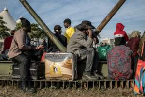 Undocumented migrants lined up at a repatriation site in Durban.  By MARCO LONGARI (AFP)
