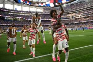 United States striker Folarin Balogun celebrates with team-mates after scoring in the World Cup co-hosts victory over Paraguay.  By Patrick T. Fallon (AFP)