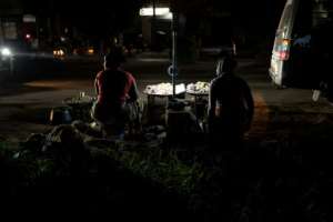 Vendors sell groundnuts on the side of the road during a power outage in Westfield, The Gambia.  By MUHAMADOU BITTAYE (AFP)