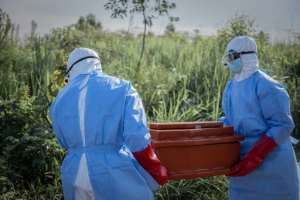 Volunteers wearing protective equipment carry the coffin of a three-year-old child, presumed to have died of Ebola, in Bunia.  By Benediction MURHABAZI (AFP)