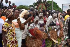 Women adorned in traditional body paint watched the funeral cortege.  By MATTHEW JACOBS (AFP)
