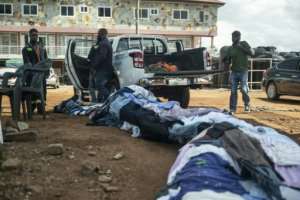 Workers prepare clothes for the installation.  By CLAUDIA LACAVE (AFP)
