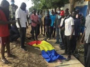 A body lies covered with the Chadian flag during the clashes that broke out in NDjamena on October 20. By - AFP