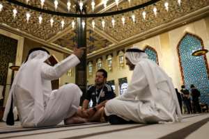 A football fan chats with Gulf residents inside the Blue Mosque. By MAHMUD HAMS AFP