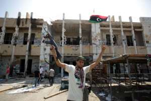 A Libyan rebel fighter celebrates the seizure of Bab al-Aziziya in August 2011 after NATO bombardment destroyed much of the sprawling compound. By PATRICK BAZ AFPFile
