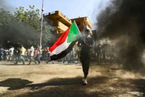A man waves a Sudanese national flag at a demonstration in Khartoum on November 30. By Ashraf SHAZLY AFP