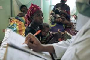 A mother with her malnourished child speaks with a doctor at Rutshuru Hospital. By ALEXIS HUGUET AFP