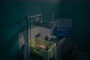 A newborn baby sleeps in the same room as gunshot victims on the mend. By ALEXIS HUGUET AFP