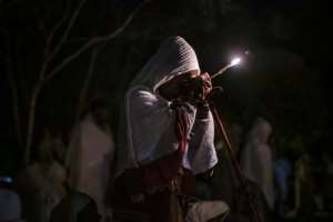 A pilgrim holds a candle at St. Mary's Church. Lalibela has changed hands repeatedly during Ethiopia's bloody conflict. By EDUARDO SOTERAS AFP