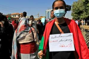 A Sudanese protester carries a placard which reads in Arabic, long live the struggle of women, they alone can break the silence of oppression. By ASHRAF SHAZLY AFP