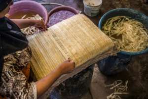 A woman lays out soaked thin strips of papyrus to form a sheet, before compression and drying at the workshop. By Khaled DESOUKI AFP