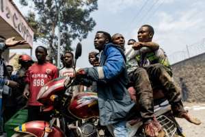 An injured man was taken away by motorbike outside the UN supplies base in Goma on Monday. By Michel Lunanga AFP