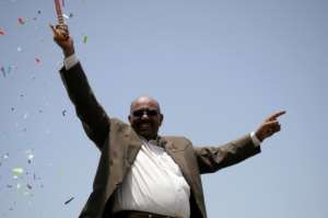 Bashir waves to the crowd at the inauguration of a factory near Al-Dewaim city in White Nile state on July 11, 2012. By ASHRAF SHAZLY AFPFile