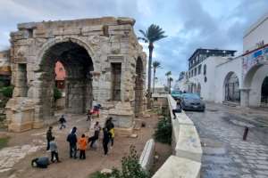 Children play by the Roman arch of Marcus Aurelius, built in 165 AD, in the ruins of ancient Oea by the modern port of Libya's capital Tripoli on December 13, 2021. By Mahmud Turkia AFP