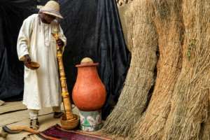 Dafallah al-Haj Ali Mustafa pours water down the pipe of the traditional wazza instrument to wet and soften it before playing.  By ASHRAF SHAZLY AFP