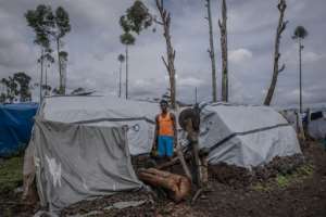 Diela Bazi, 20, a secondary-school student, next to his shelter. He looks after his siblings after they were separated from the rest of the family during their escape from their home in the village of Rugari. By Guerchom Ndebo AFP