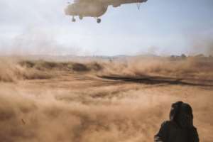Dust: A UN aid helicopter arrives at the Rhoo camp for displaced people. By ALEXIS HUGUET AFP