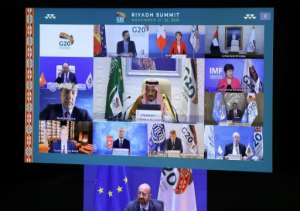 European Council President Charles Michel down and Saudi Arabia's King Salman bin Abdulaziz Al Saud are seen with other state and institution leaders on a screen before the start of a virtual G20 summit hosted by Saudi Arabia. By YVES HERMAN POOLAFP