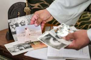 Excavator Mostafa Abdo Sadek shows pictures of family members who helped uncover the treasures of the tombs of Saqqara, southwest of Cairo. By Ahmed HASAN AFP