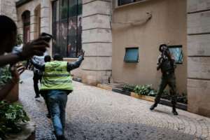 Flashback: A police officer stands guard as people are evacuated after the hotel comes under attack. By KABIR DHANJI AFPFile