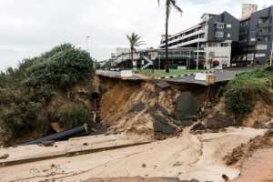 Floodwaters washed away parts of the road at the Umdloti beach resort north of Durban. By RAJESH JANTILAL AFP