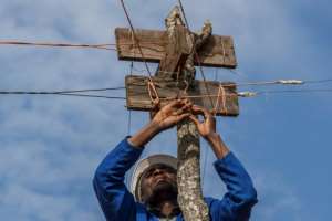 Metal cables strung along the top of tree stumps take the power from the tiny hydro plant to the village. By AMOS GUMULIRA AFP