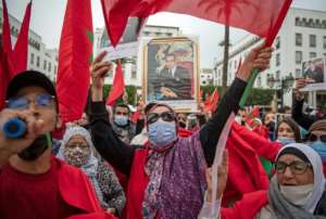Moroccans celebrate in front of the parliament building in Rabat on December 13, 2020, after the US adopted a new official map of Morocco that includes the disputed territory of Western Sahara. By FADEL SENNA AFPFile