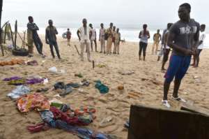 People look at clothes left on the beach following the attack. By ISSOUF SANOGO AFP