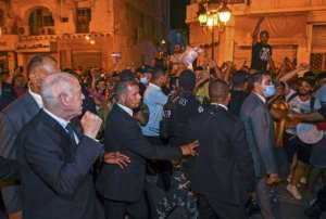 President Kais Saied raises a fist in celebration with his supporters. By - Tunisian PresidencyAFP