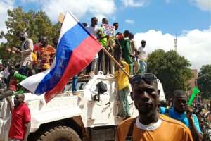 Pro-Moscow: Demonstrators waving a Russian flag stand atop a UN peacekeepers' vehicle in Ouagadougou on Sunday. By - AFP