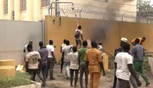 Protesters set fire to barriers outside and lobbed rocks at the structure, with some trying to scale the fence. By AFPTV teams, Idrissa OUEDRAOGO AFP