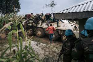 Red Cross volunteers climb onto a UN armoured vehicle after coming under attack. By ALEXIS HUGUET AFP