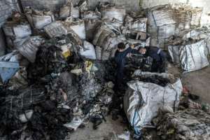 Workers sort through sacks of plastic waste at a workshop of the Egyptian startup company TileGreen. By Ahmed HASAN AFP
