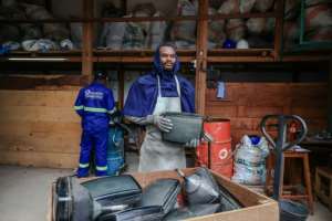 Yannick Ayi, a technician working for Solidarite Technologique, with a batch of cathode-ray tubes taken from broken TVs. By Daniel Beloumou Olomo AFP