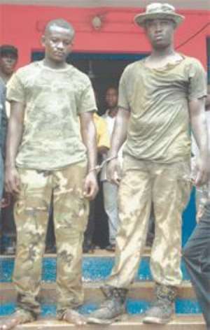 In the arms of the law: Bright Asare left, 21, and Kofi Amoateng, 22.