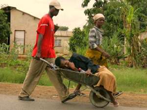 Transporting a sick person by wheelbarrow is a sad image that throws dust on Africans as not human beings