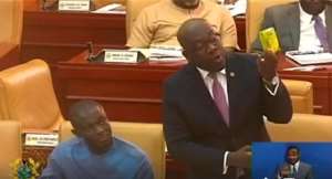 Kojo Oppongg Nkrumah displaying the fruit juice on the floor of Parliament today