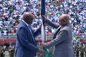 Outgoing Lesotho prime minister Moeketsi Majoro, right,  hands over the national flag as the symbol of passing power to his successor, Sam Ntsokoane Matekane, on 28 October 2022. - Source: Molise Molise/AFP via Getty Images