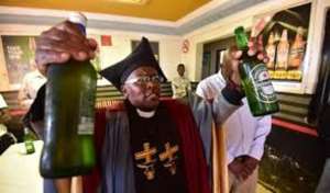 Pastor Tsietsi prays on the beer before serving