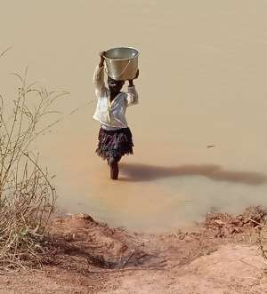 A young girl fetching water from the Dam in the Taha Community