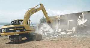 An excavator crushing one of the houses near Weija water works.