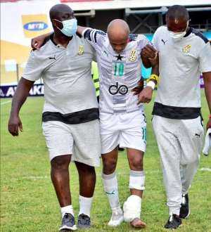 Andre Ayew being assisted by team doctors after the game