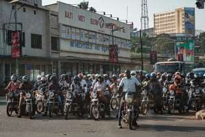 Motorcyclists at a traffic light in Kampala, Uganda. - Source: Photo by Yasuyoshi Chiba/AFP via Getty Images